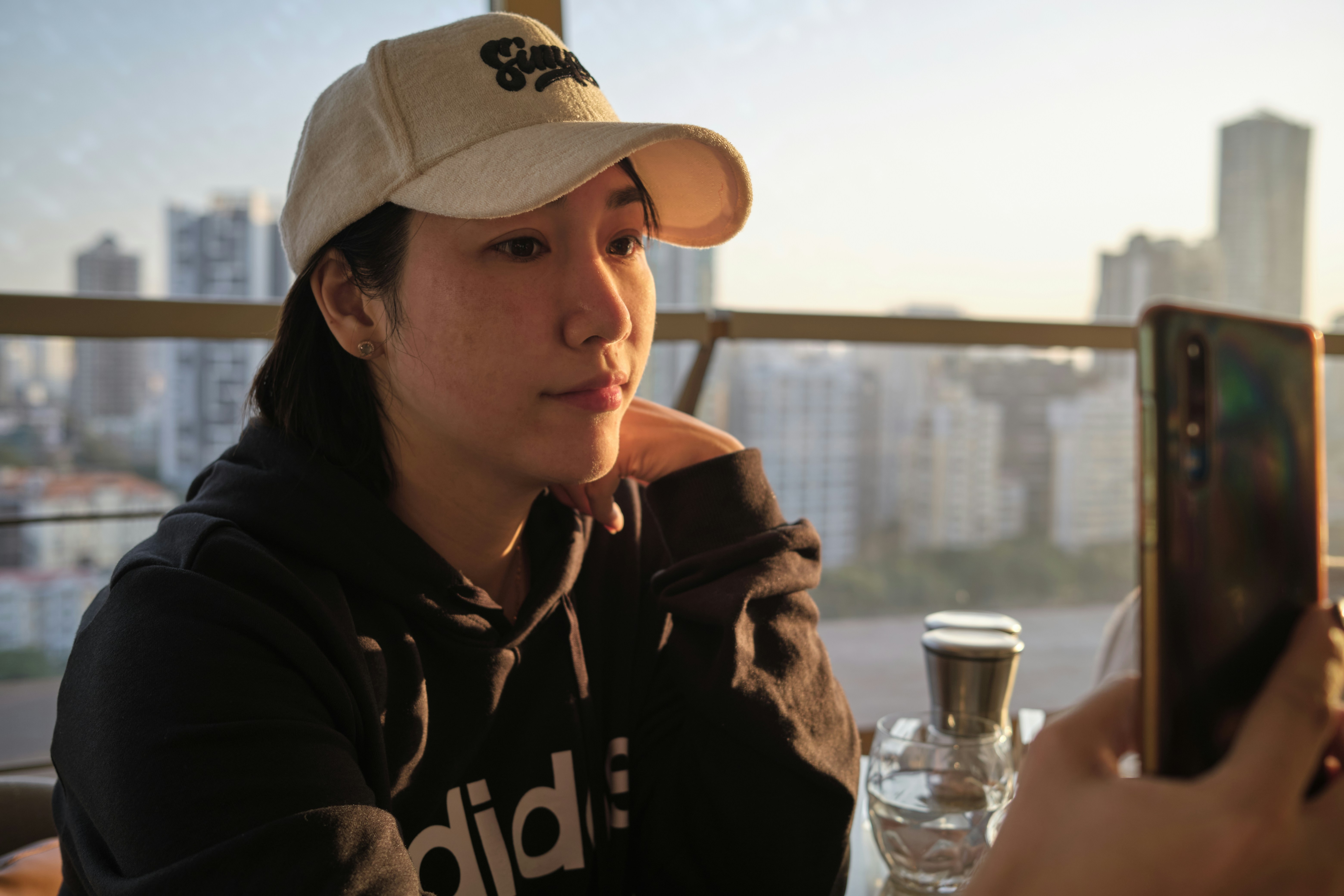 a woman sitting at a table with a cell phone