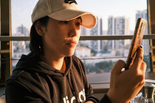 woman in black and white hoodie wearing white cap