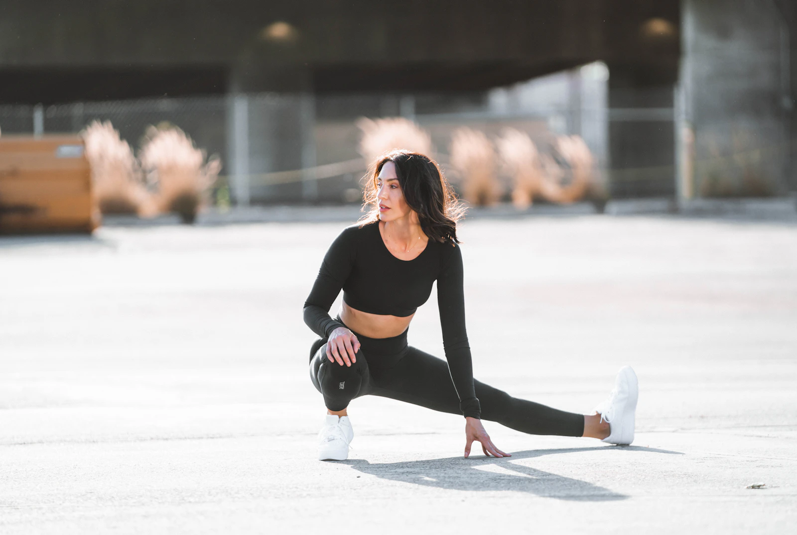 Atleta alongando vestindo conjunto fitness preto FitFemme