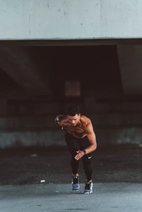 Dynamic shot of a runner sprinting on an urban track at dawn, wearing electric blue Pulseforge running gear.