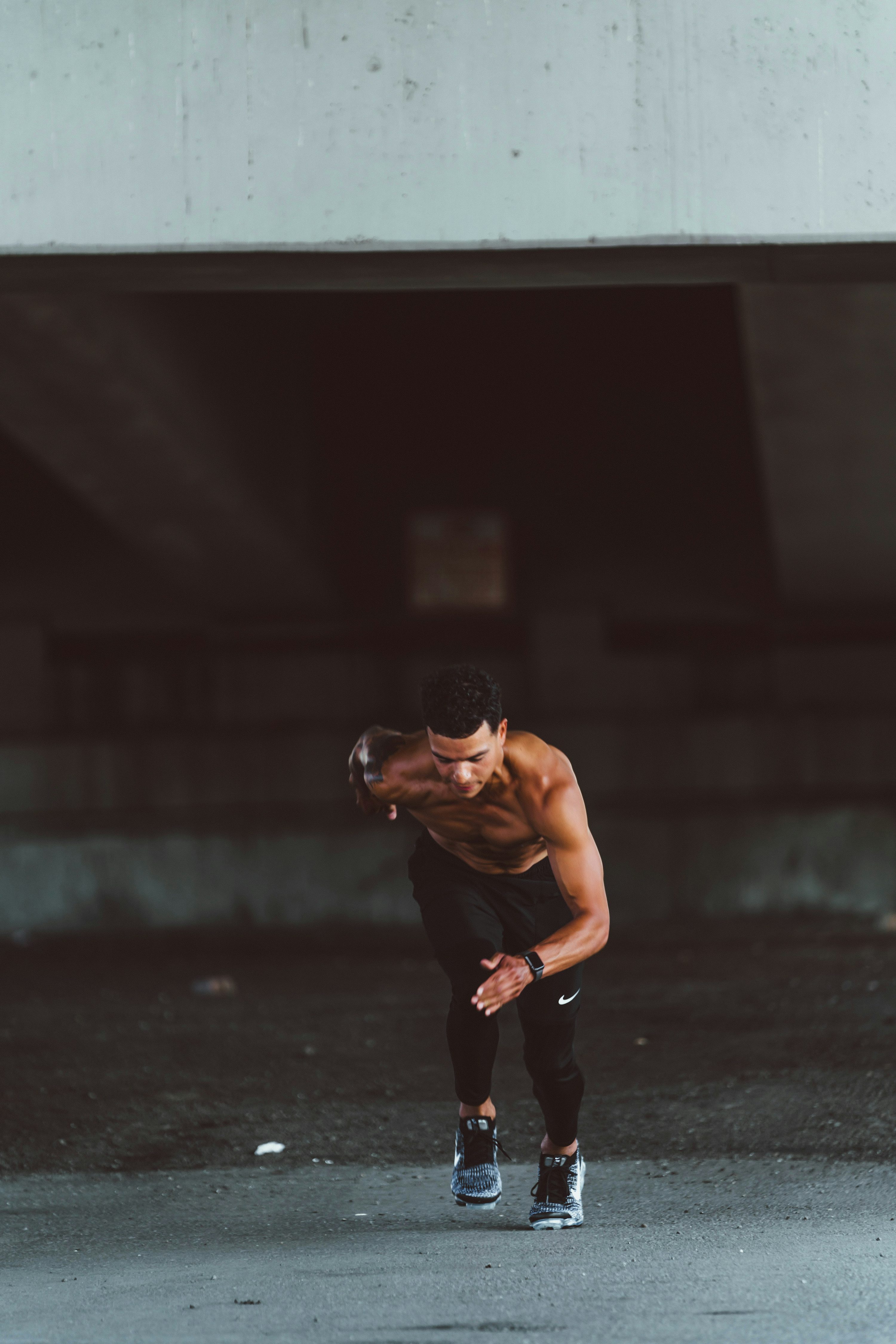 topless man in black pants and black shoes