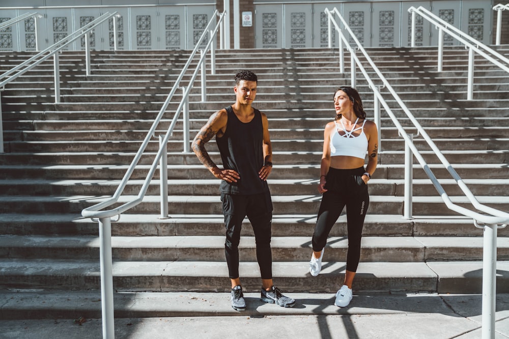 woman in black tank top and black pants standing on gray concrete stairs