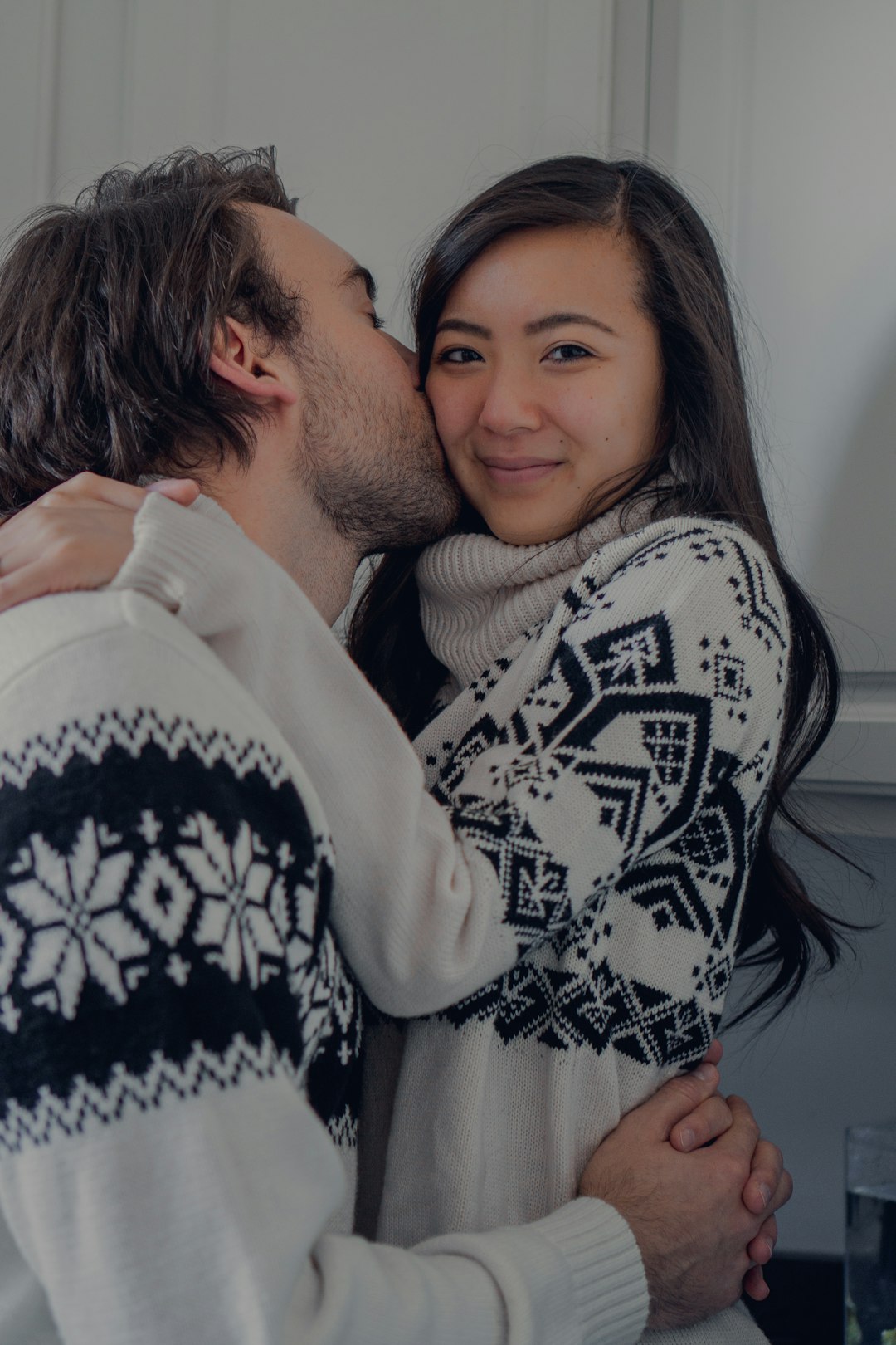 woman in black and white sweater hugging man in white shirt