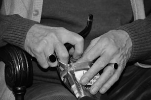 grayscale photo of person holding bottle