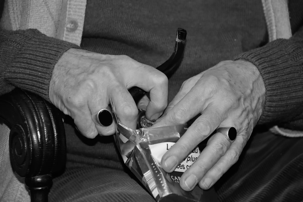 grayscale photo of person holding bottle