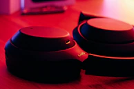 A sleek pair of premium wireless headphones resting on a wooden table with soft natural light highlighting their elegant design.