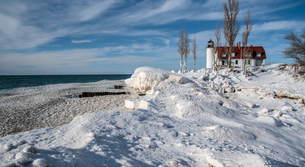 white snow covered field near body of water during daytime