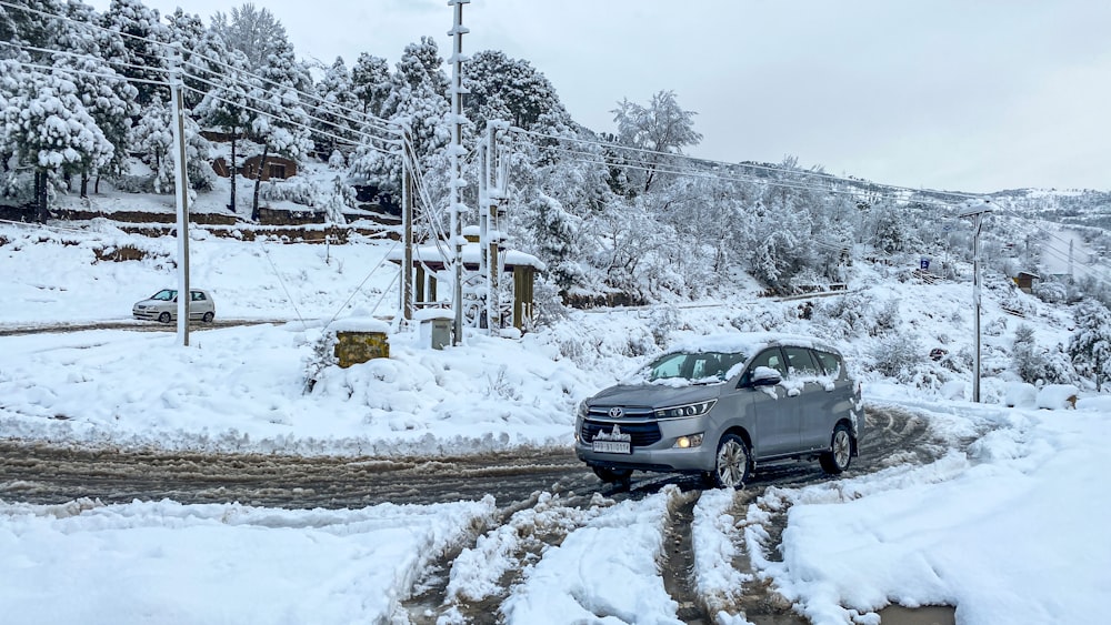 black suv on snow covered road during daytime