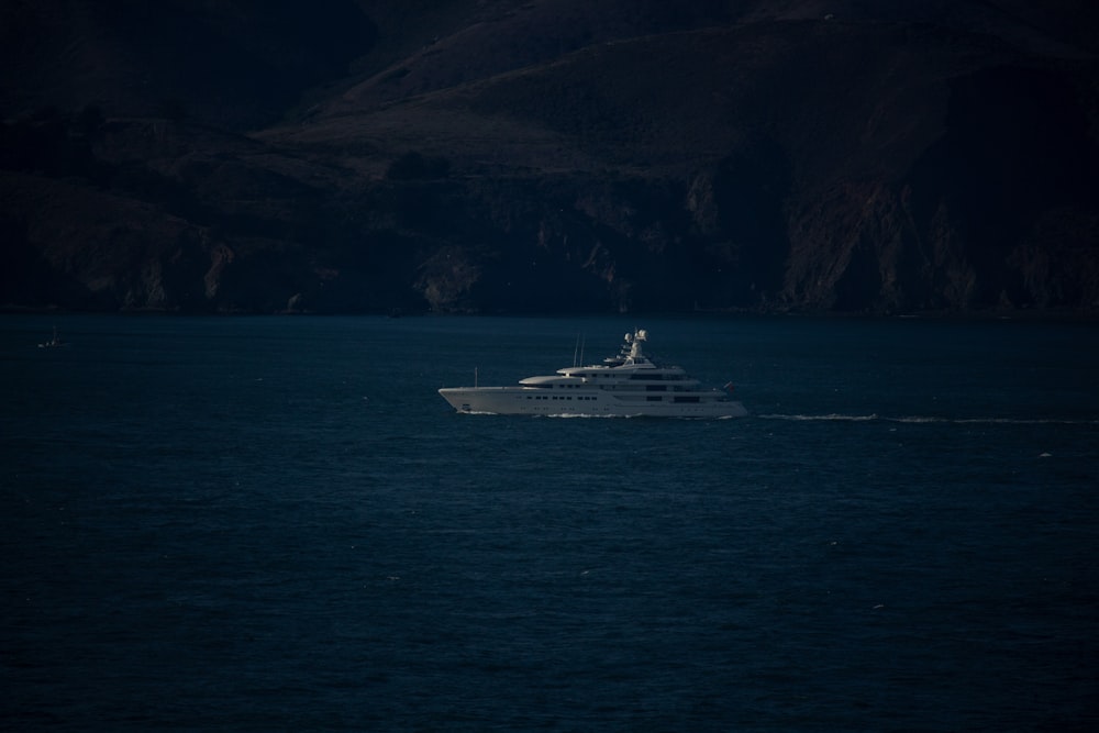 navio branco no mar perto da montanha durante o dia