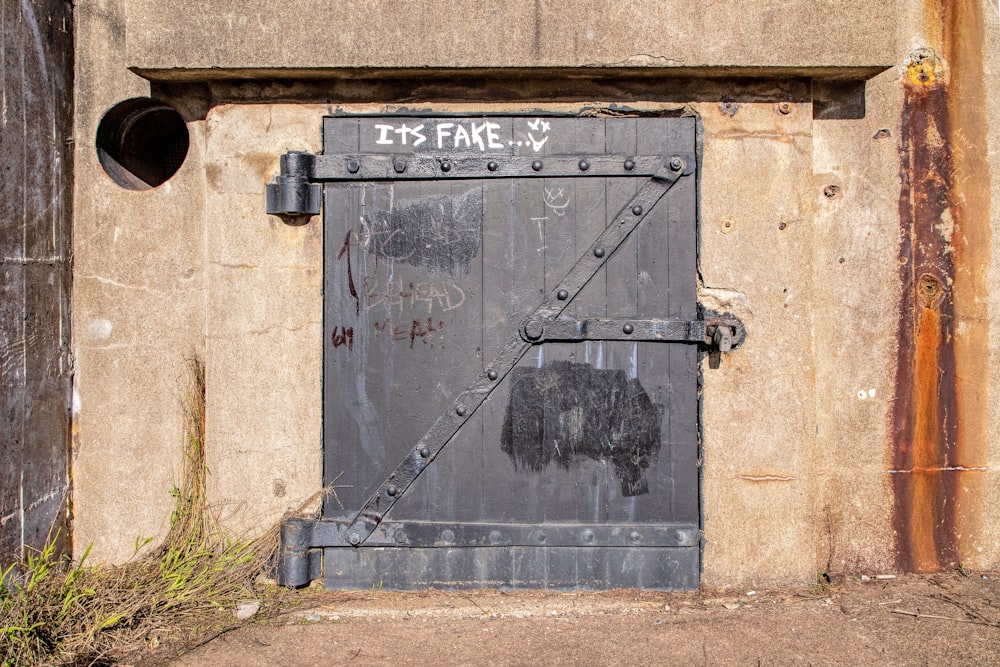 black metal door on brown concrete wall