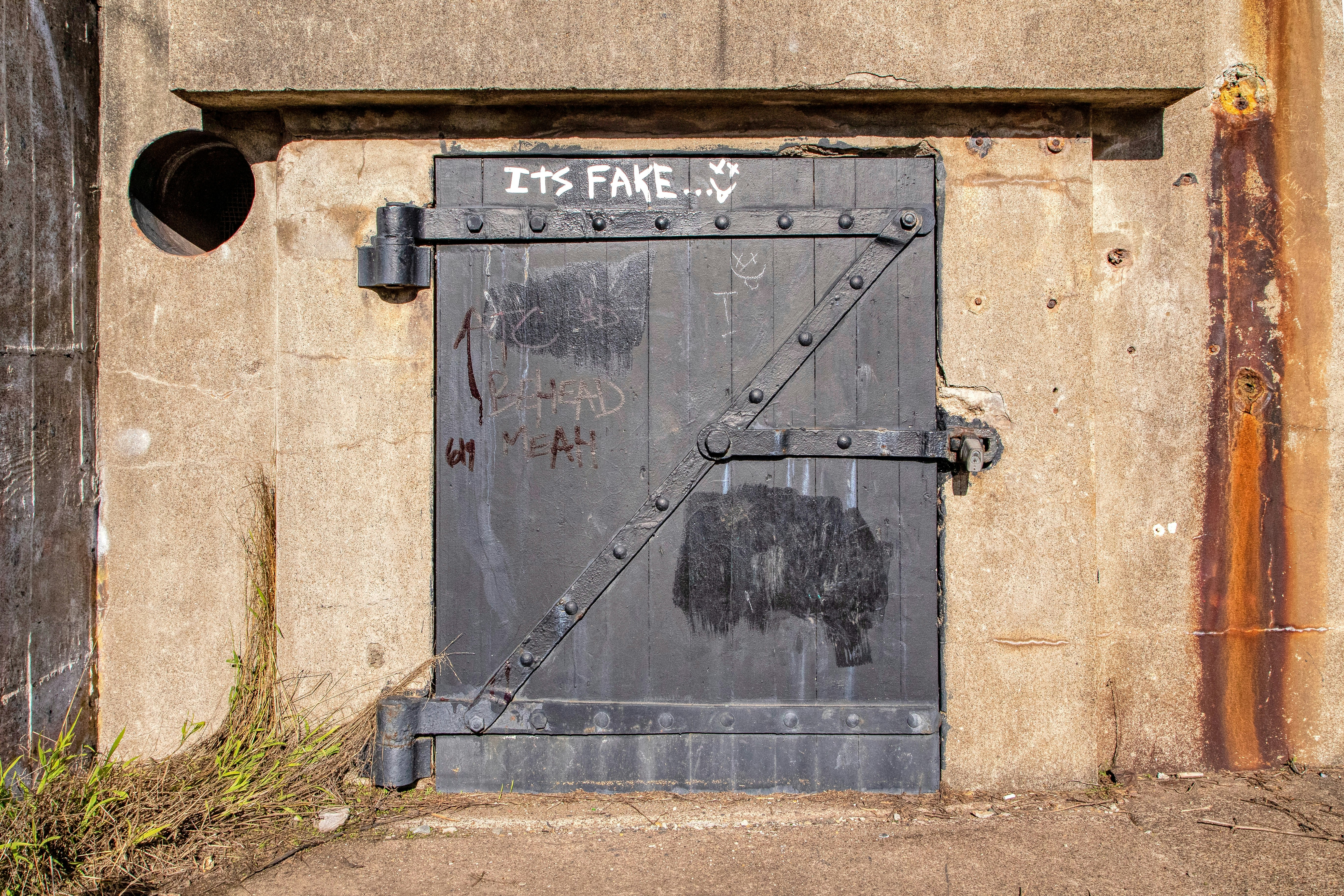black metal door on brown concrete wall