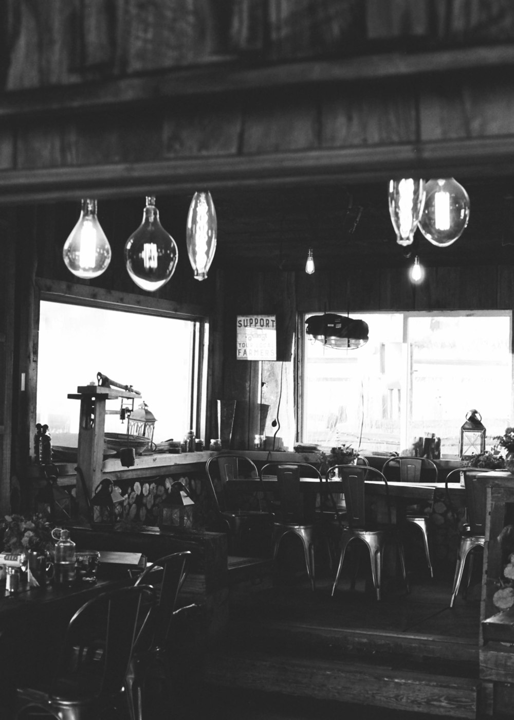 grayscale photo of empty chairs and tables