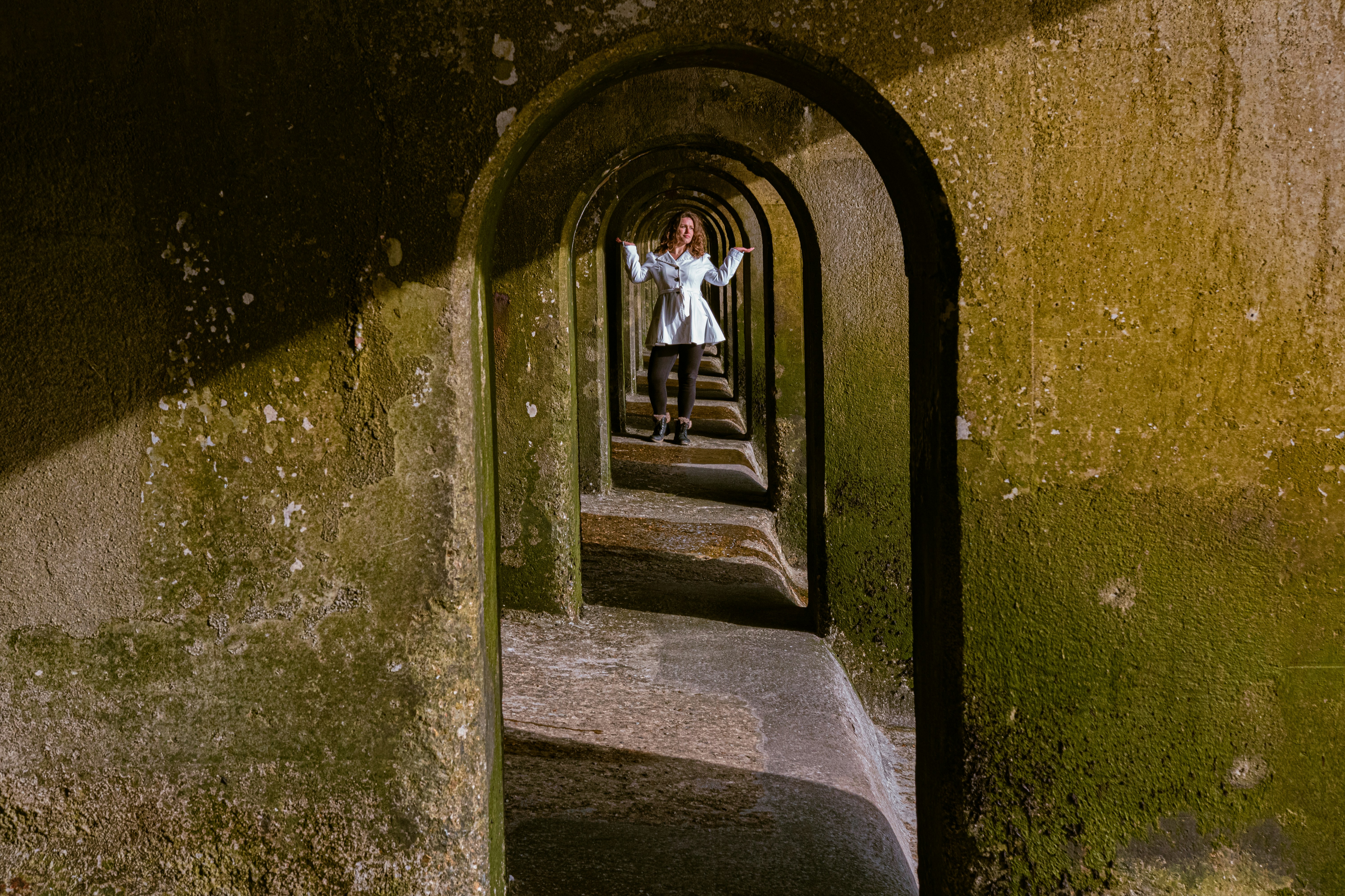 person in white shirt and black pants standing on stairs