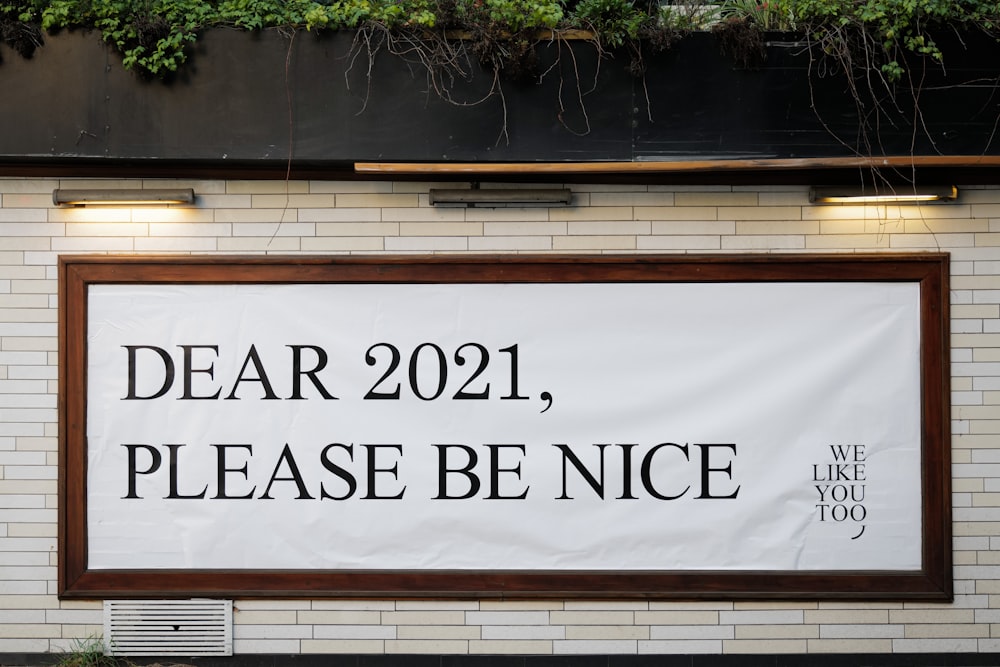 a sign on the side of a building that says dear 2021, please be nice