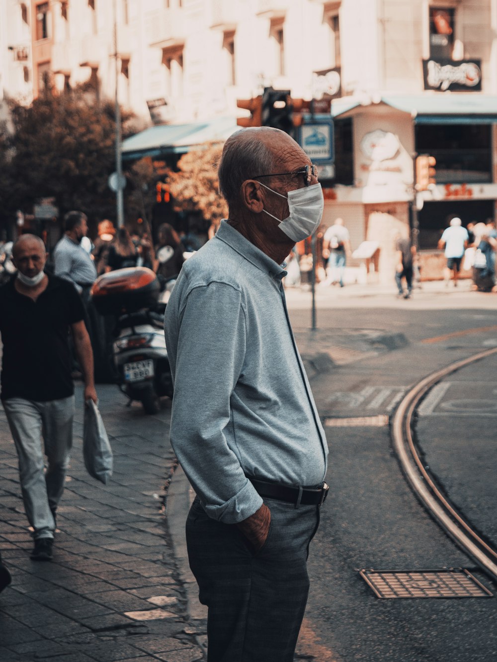 man in gray hoodie walking on street during daytime