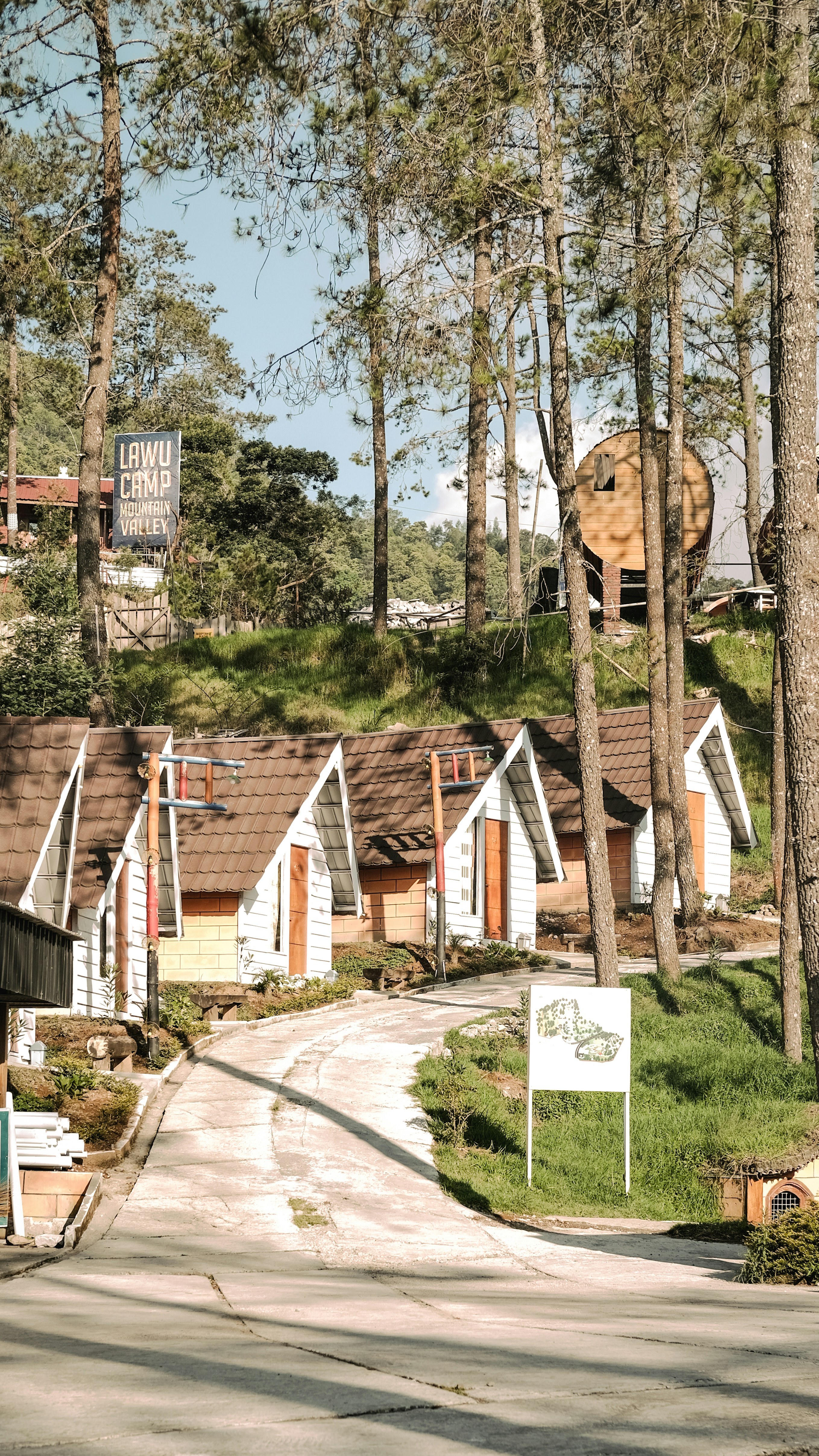 昼間の木の近くの茶色の木造住宅