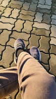 A pair of rubber-soled shoes resting on a city sidewalk, catching the afternoon light.