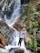 woman in black tank top and black pants standing on rock near waterfalls during daytime