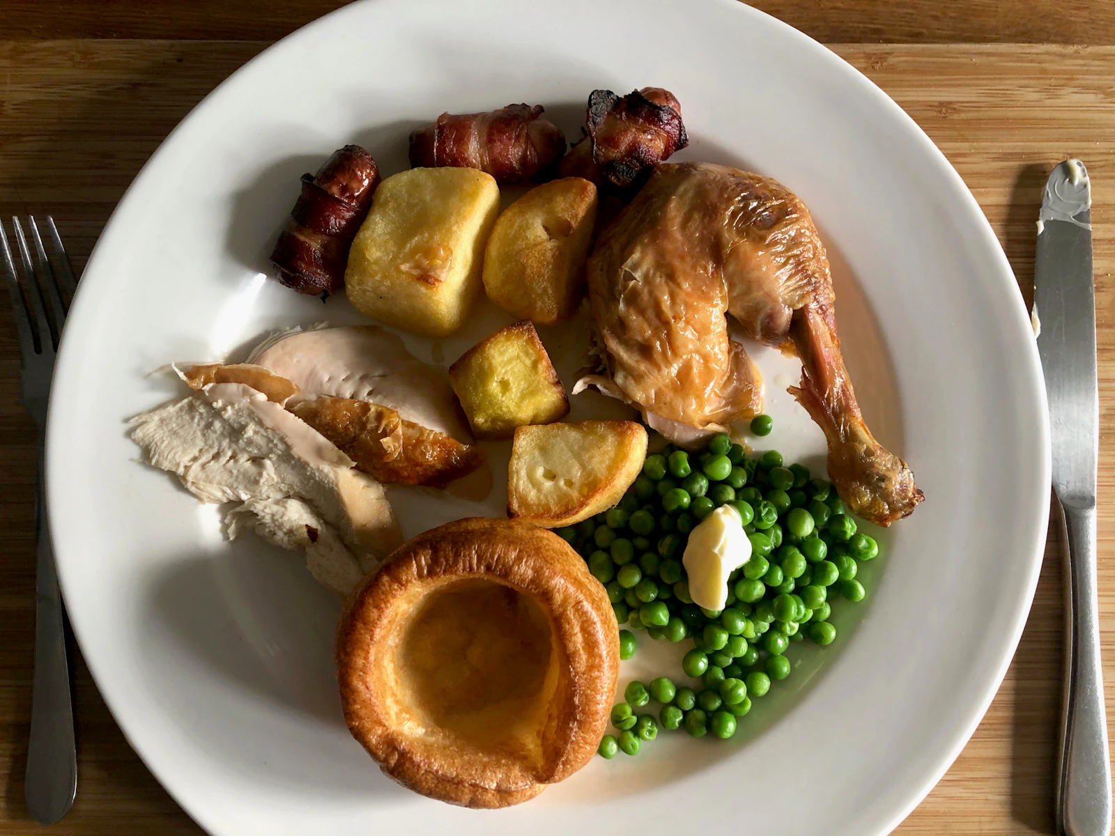 Assiette de poulet rôti avec pommes de terre, petits pois et une part de blanc tranché