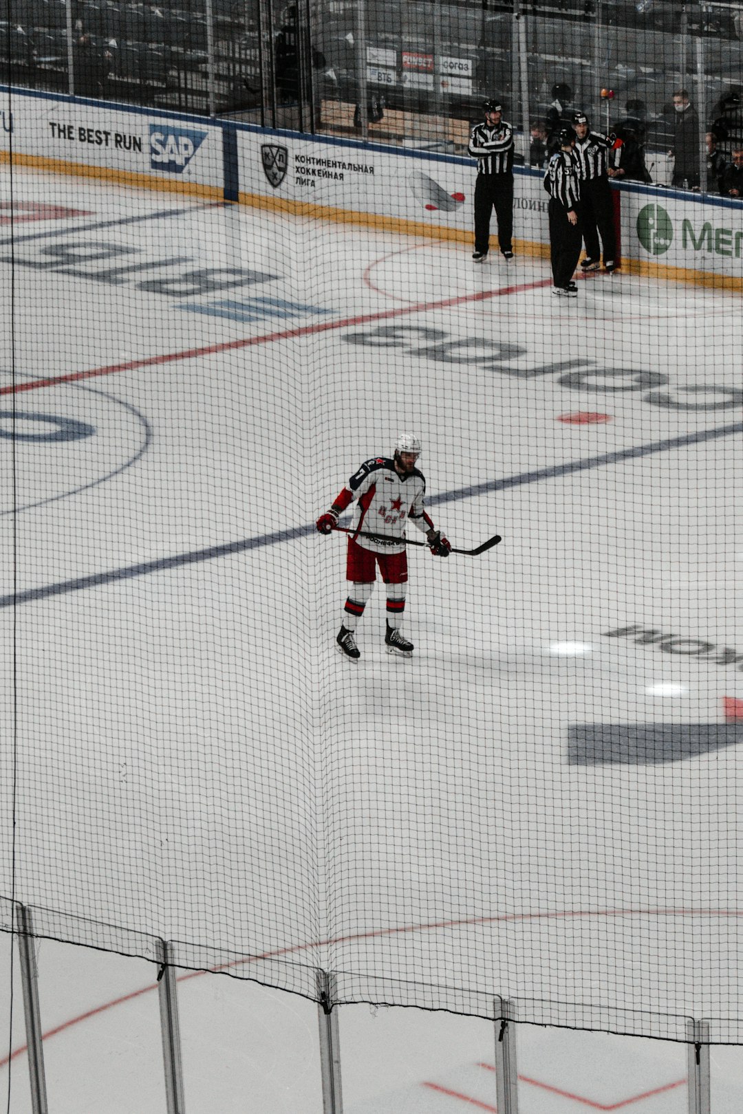 man in white and red jersey shirt and black pants playing ice hockey