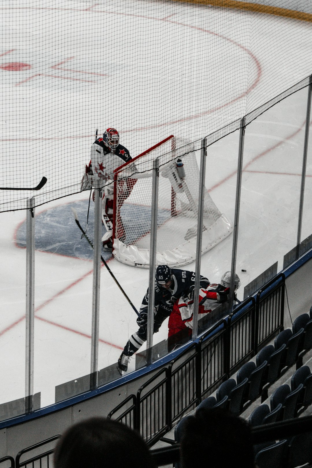 people playing ice hockey on ice field during daytime