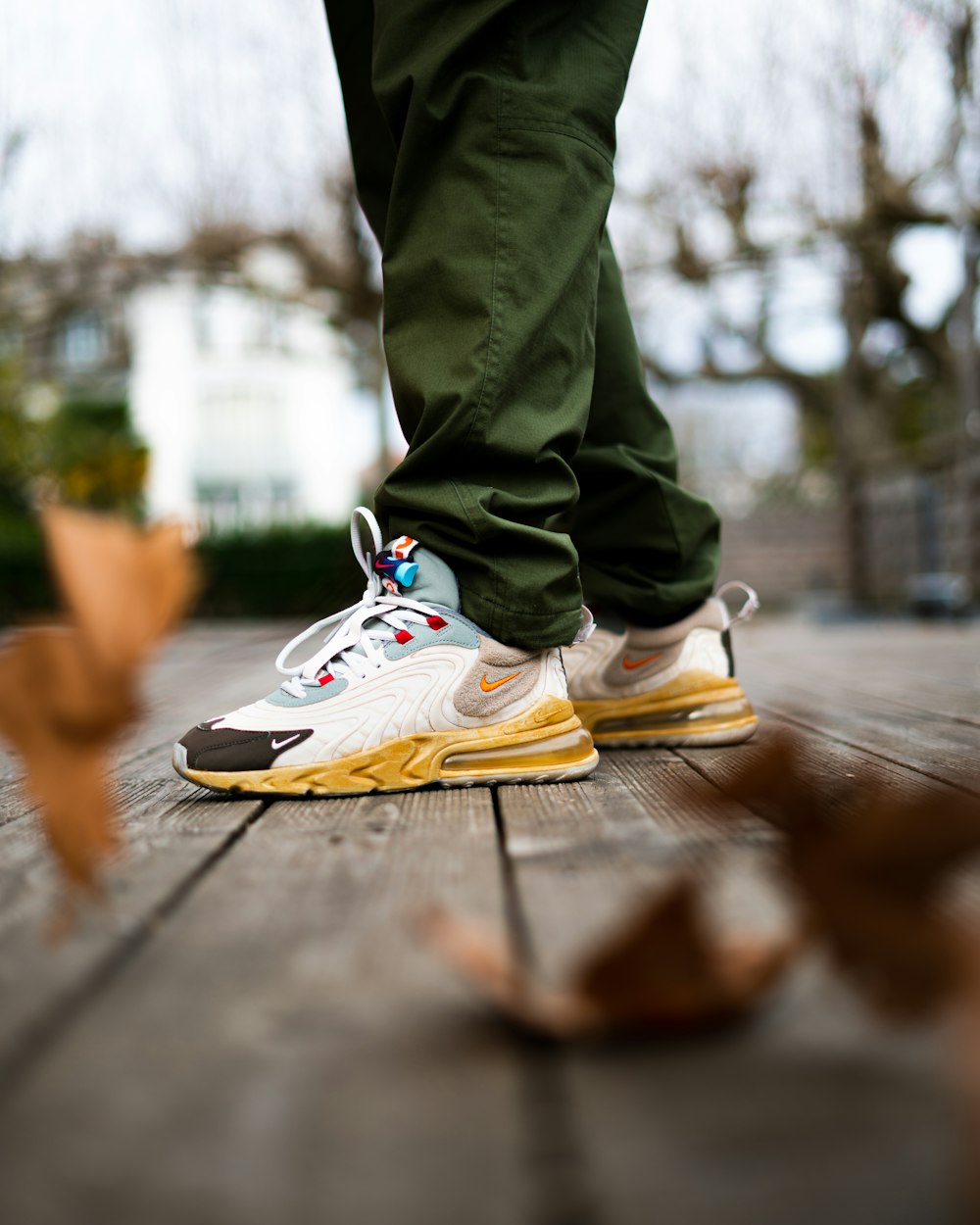 Foto de persona con pantalones grises y zapatillas nike blancas y amarillas  – Imagen gratuita Zapatilla en Unsplash