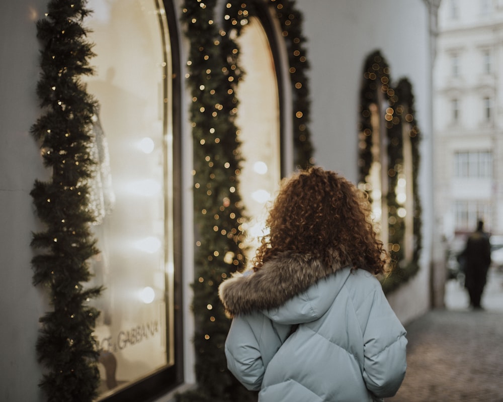 a woman walking down a street next to a building