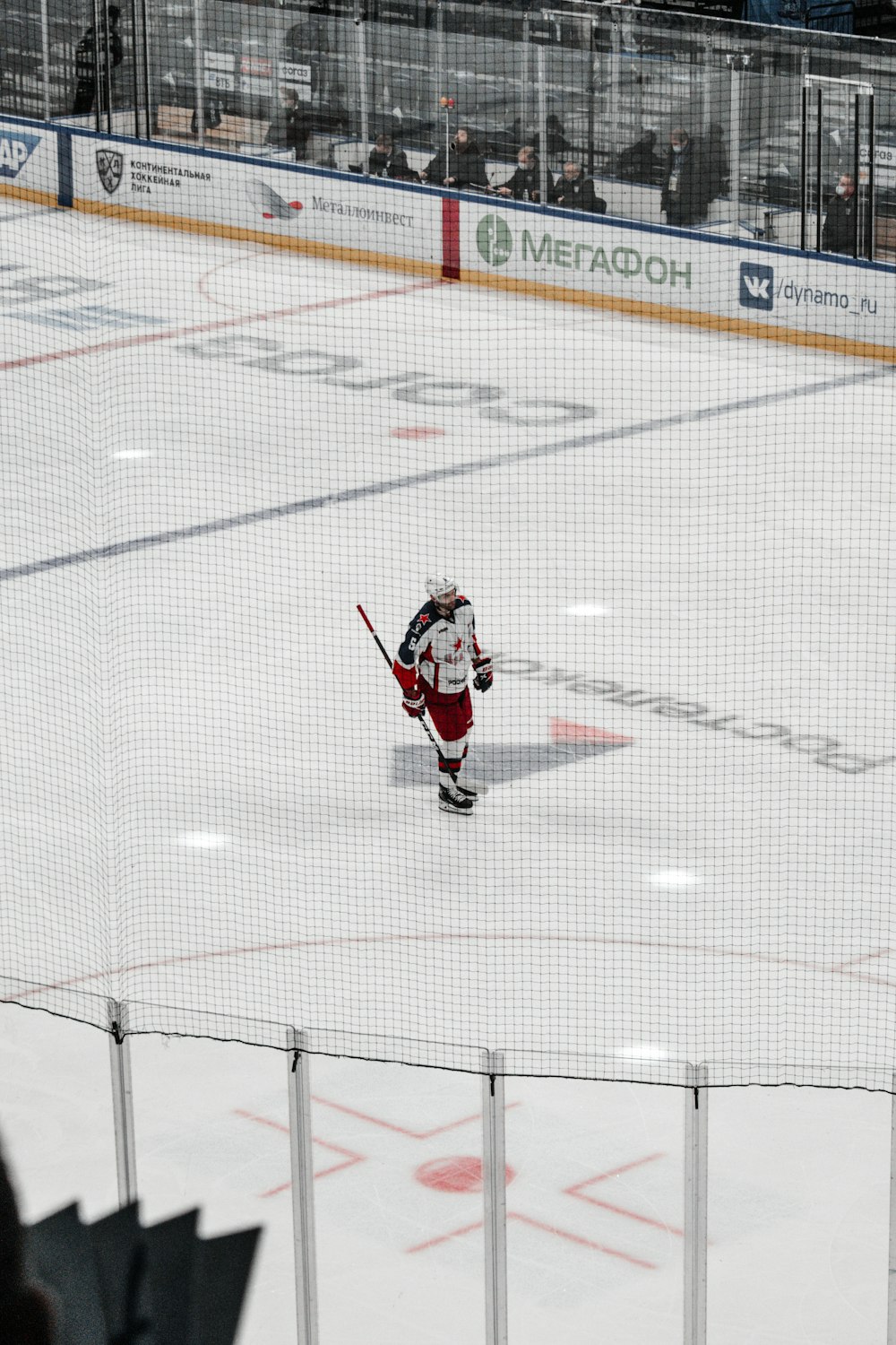 Hombre con camisa de jersey rojo y pantalones negros jugando al hockey