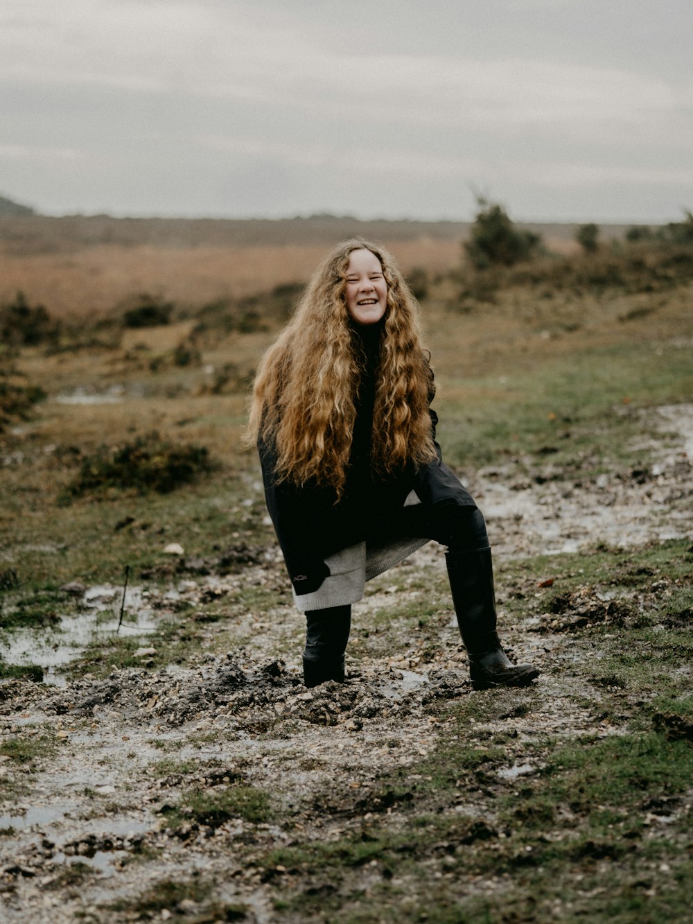 woman in black jacket and black pants standing on gray dirt ground during daytime