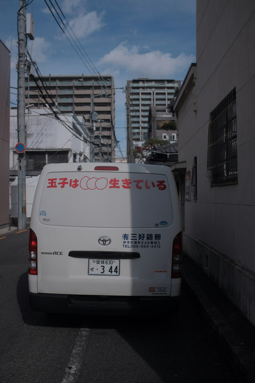 white van parked beside white concrete building during daytime