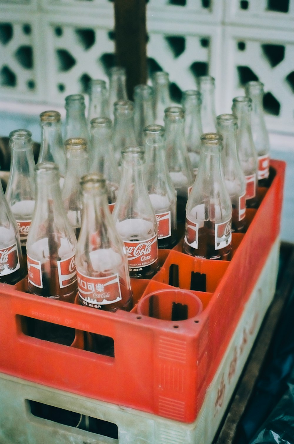 coca cola bottles on red plastic crate
