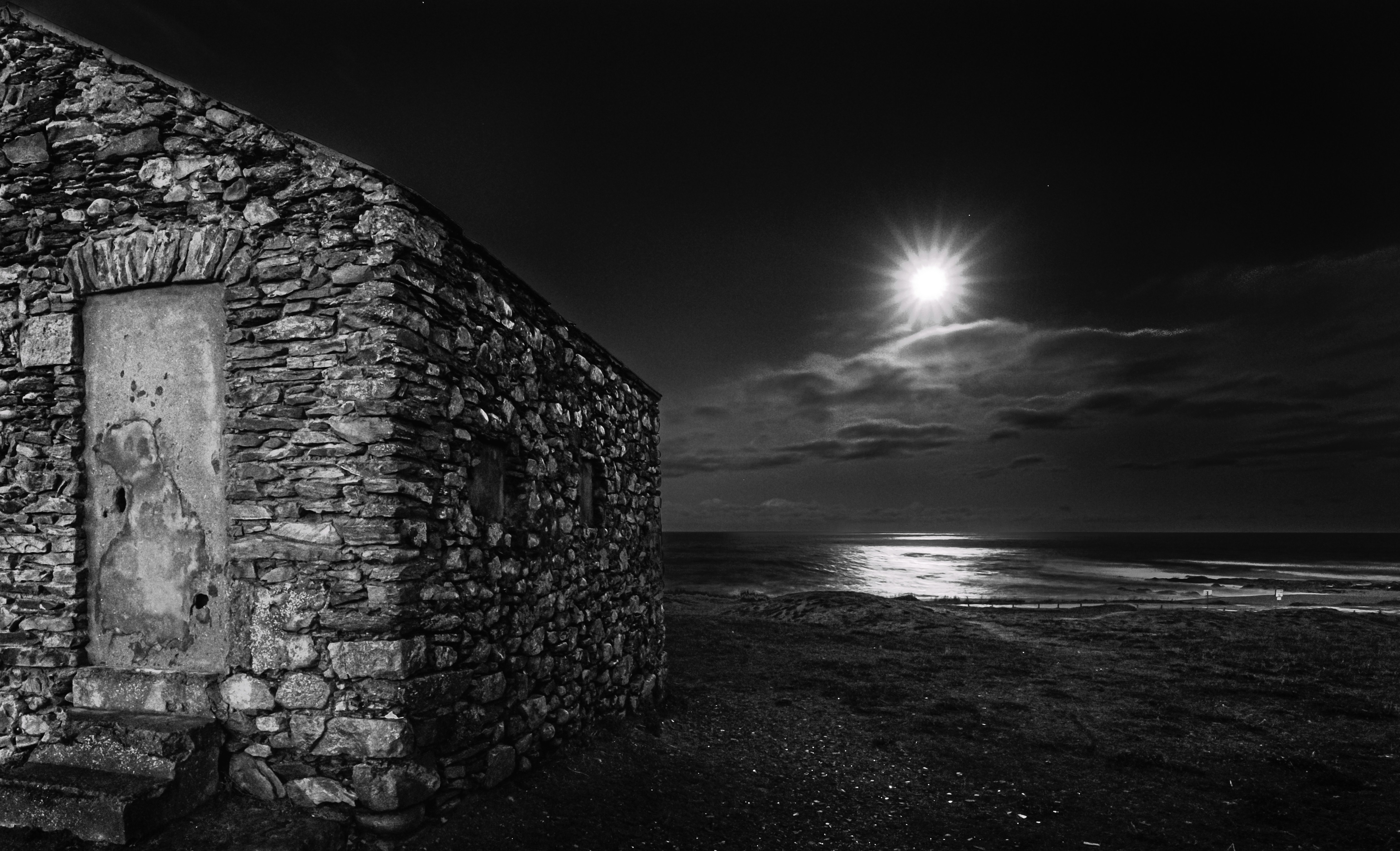 gray brick wall near body of water during night time