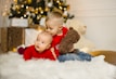 boy in red long sleeve shirt sitting on white fur textile