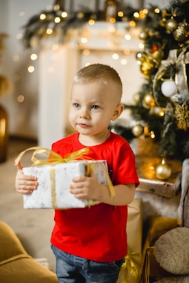 boy in red crew neck t-shirt holding white plastic container