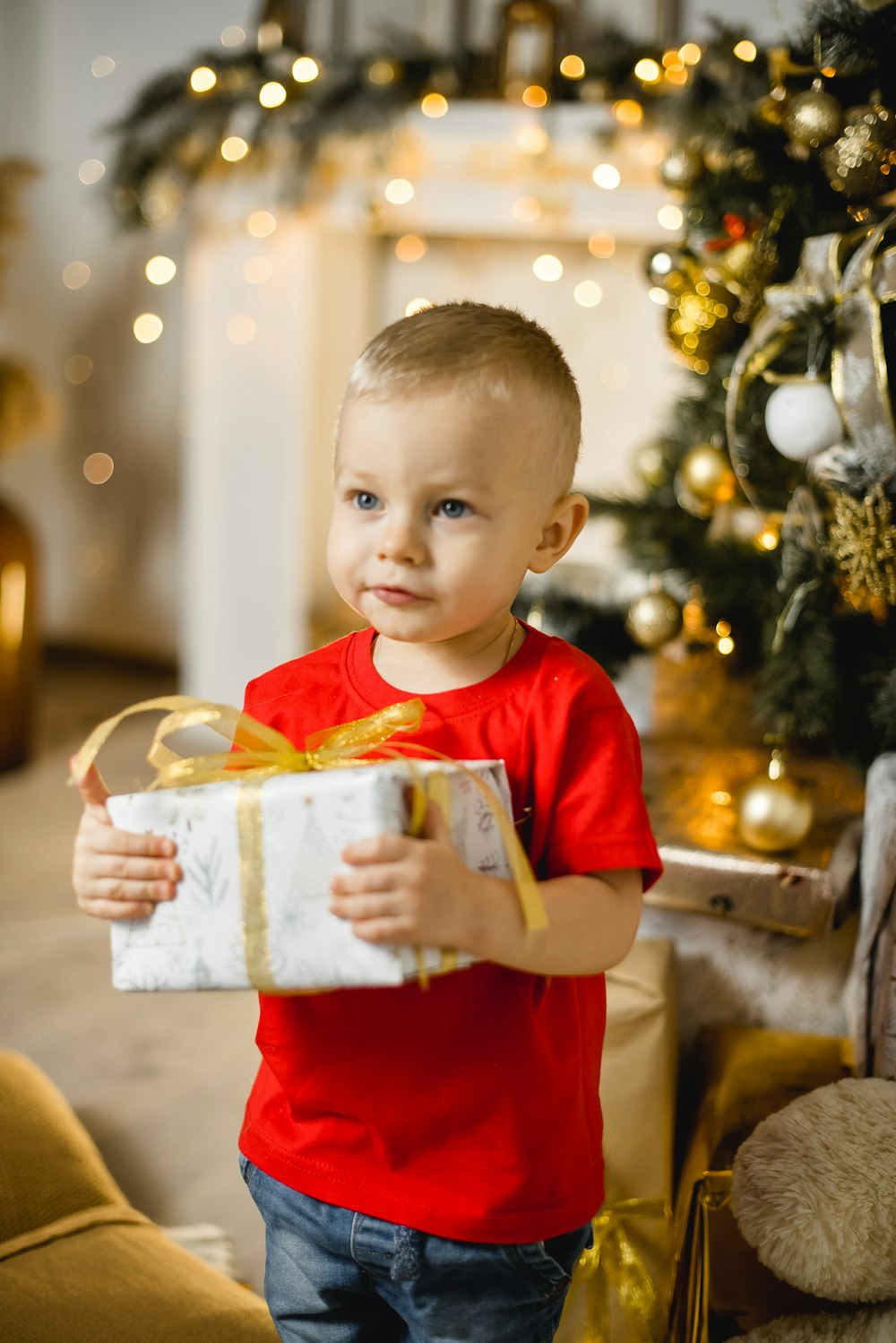 boy in red crew neck t-shirt holding white plastic container