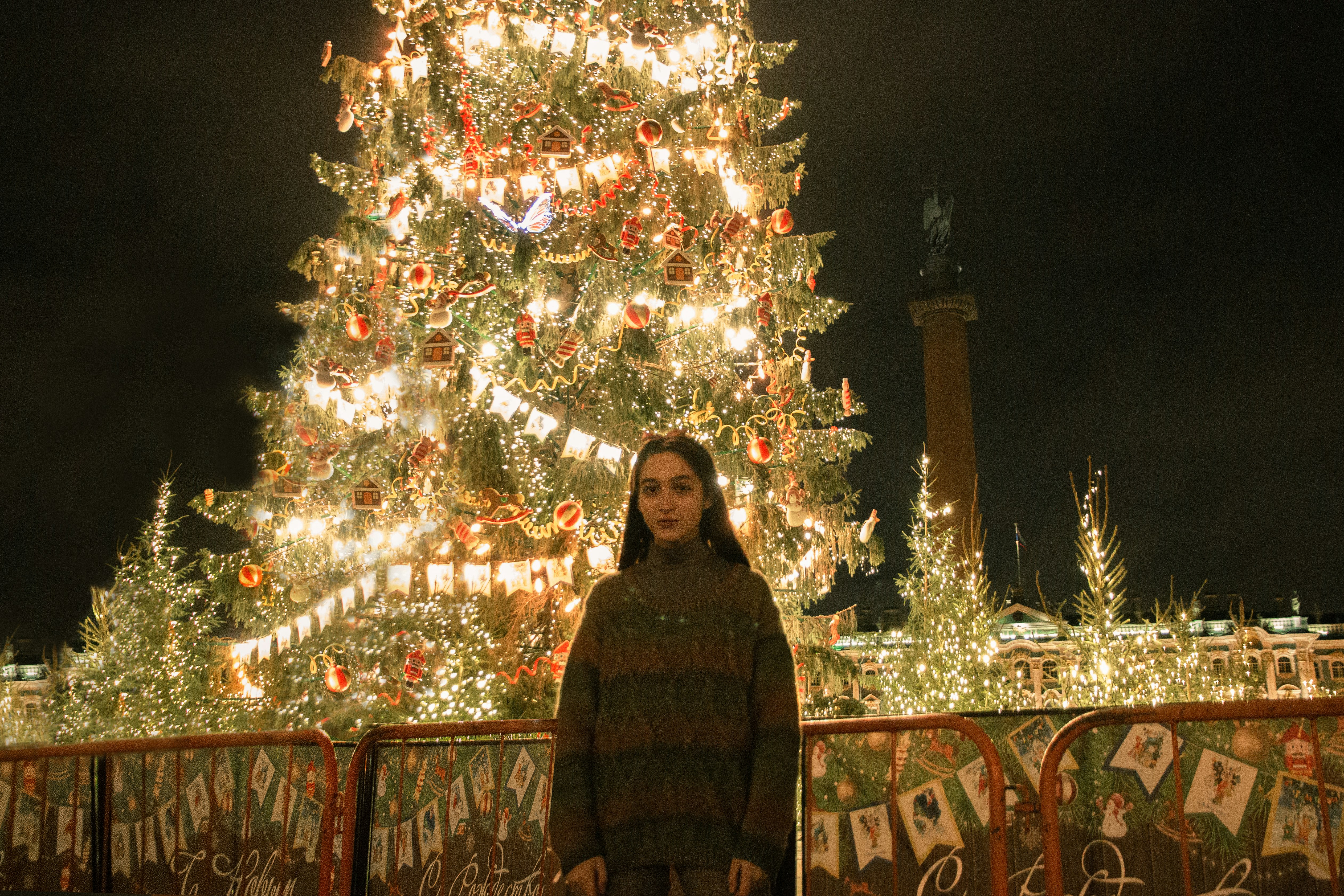 woman in black hijab standing beside christmas tree