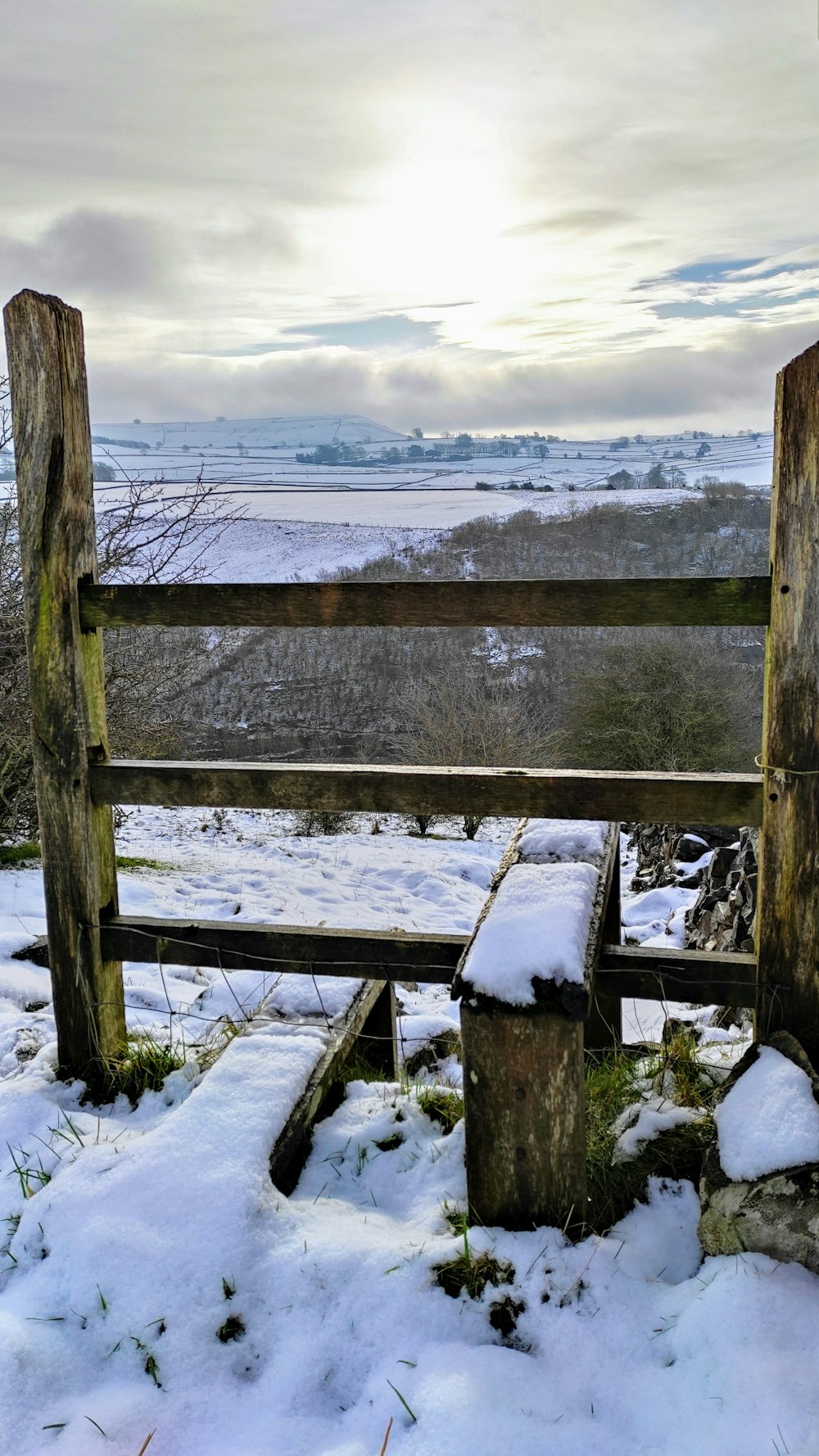 brown wooden fence on snow covered ground during daytime