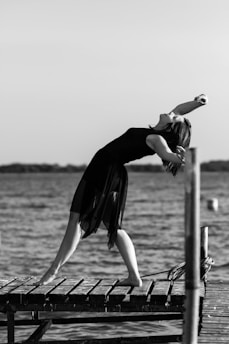 woman in black dress jumping on water