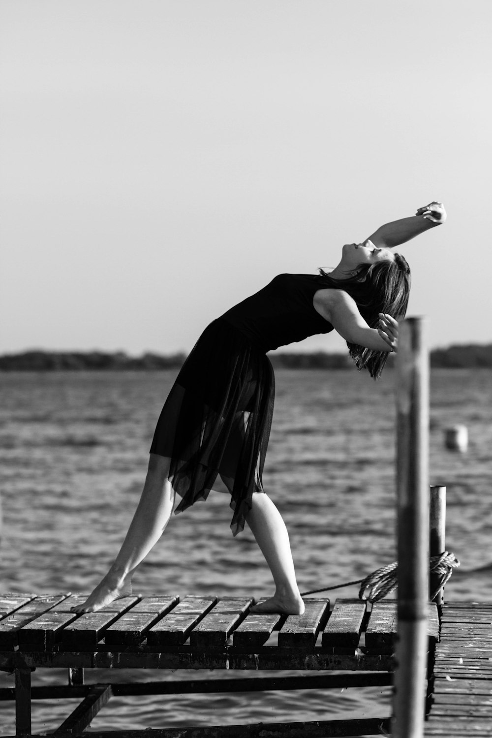 woman in black dress jumping on water