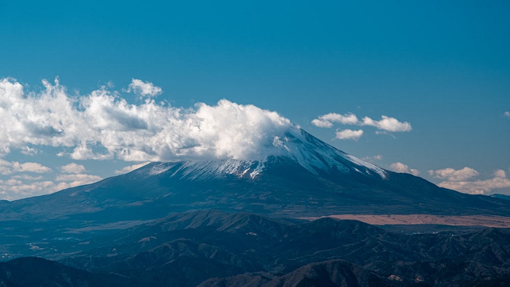 white clouds over snow covered mountain