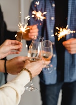 woman in white long sleeve shirt holding clear wine glass