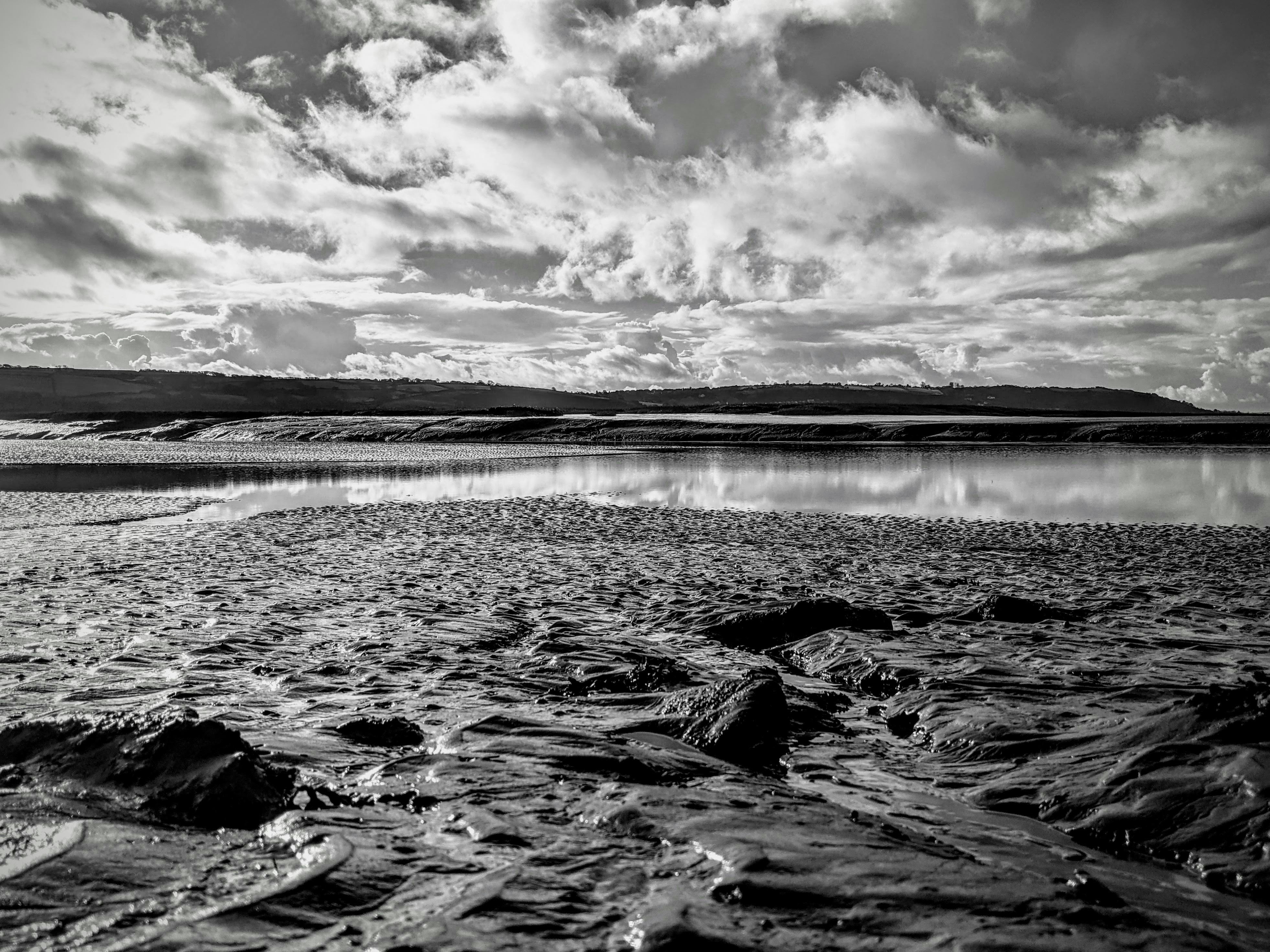grayscale photo of body of water under cloudy sky, 