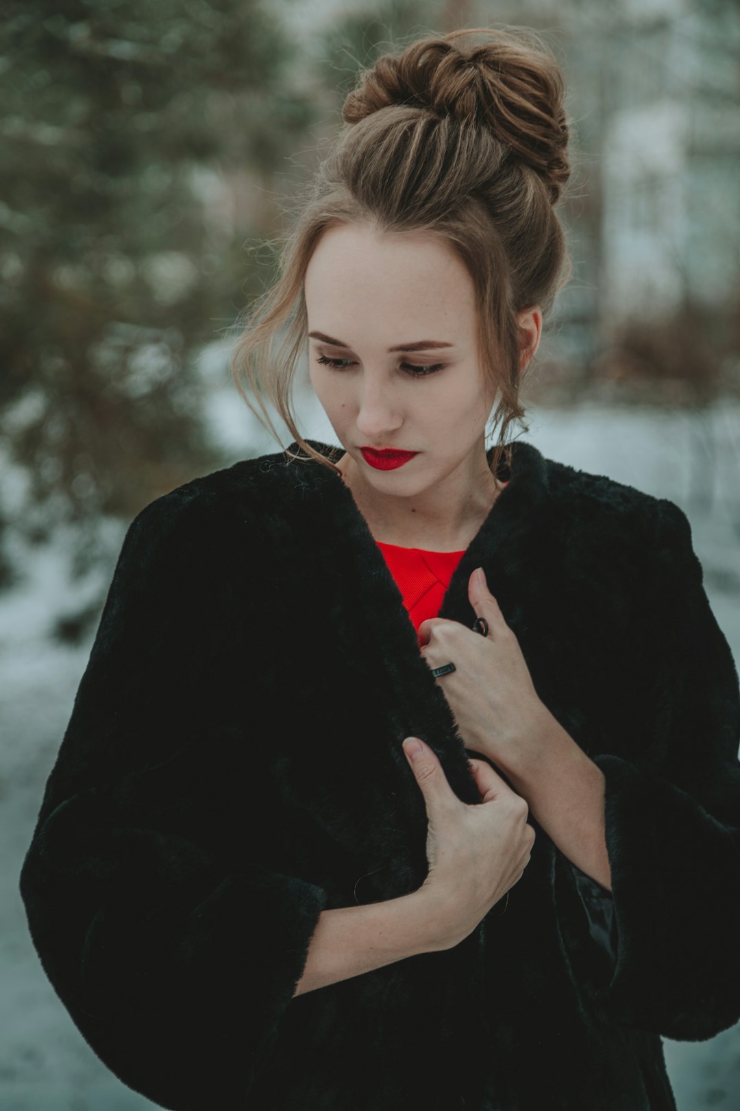 woman in black coat standing near snow covered trees during daytime