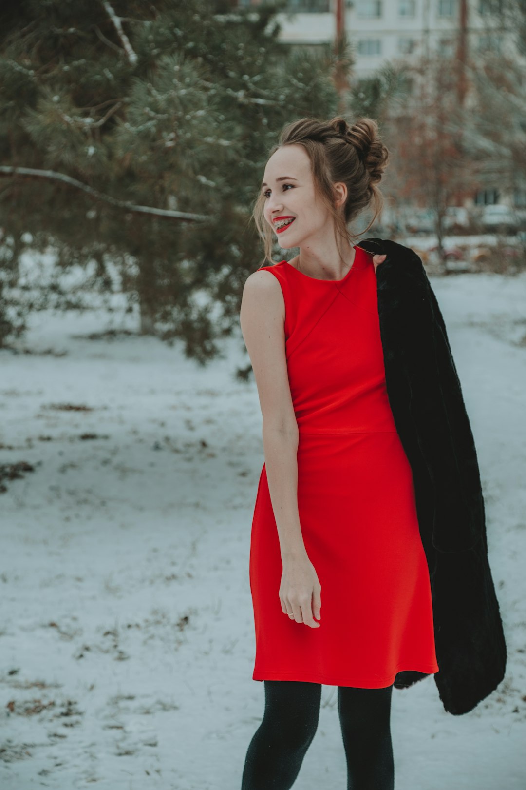 woman in red sleeveless dress standing on snow covered ground during daytime