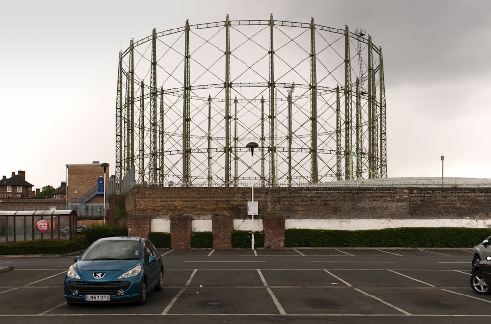 blue car parked beside brown concrete building during daytime