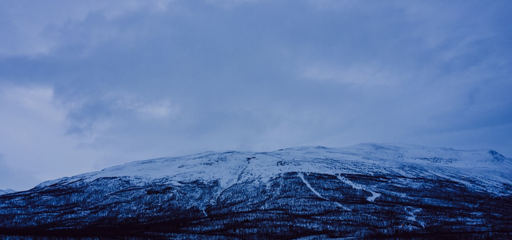 snow covered mountain under cloudy sky during daytime