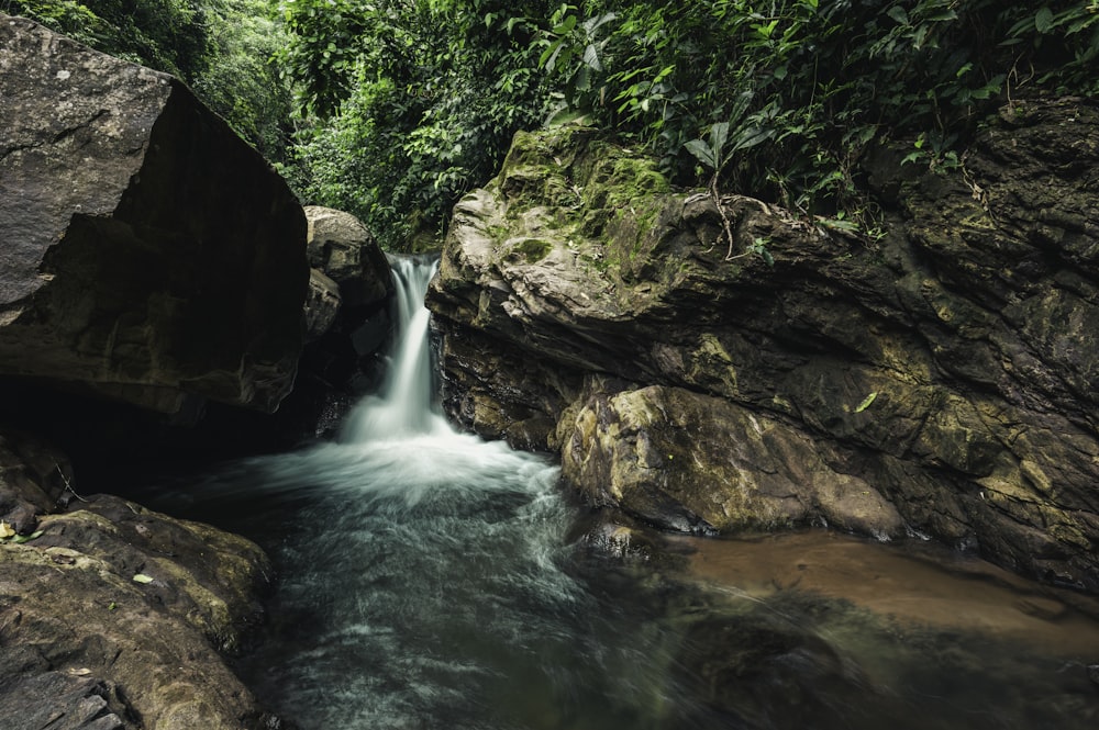 brown and green rock formation beside river during daytime