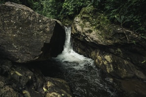 river in between brown rocky mountain during daytime