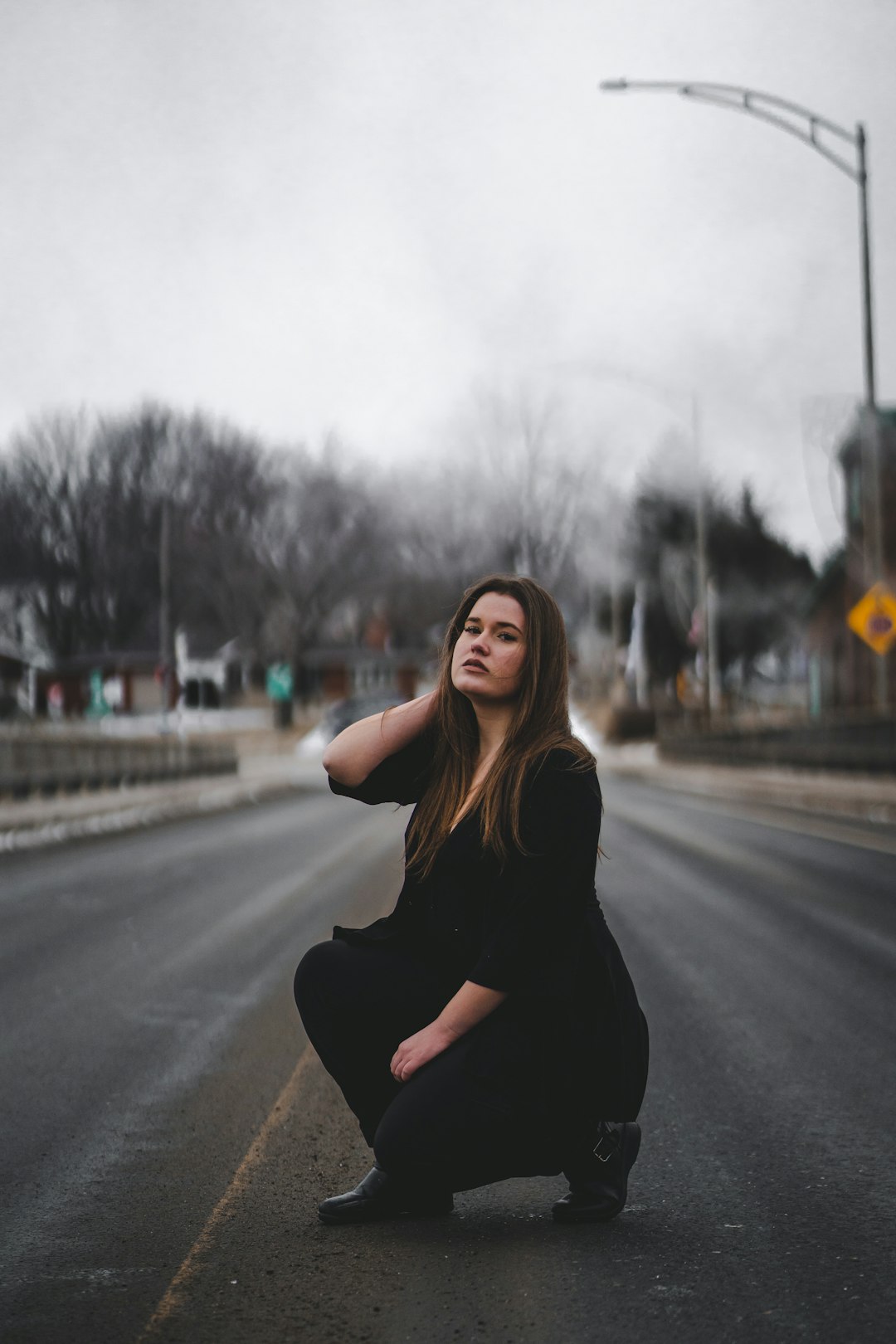 woman in black long sleeve shirt sitting on road during daytime