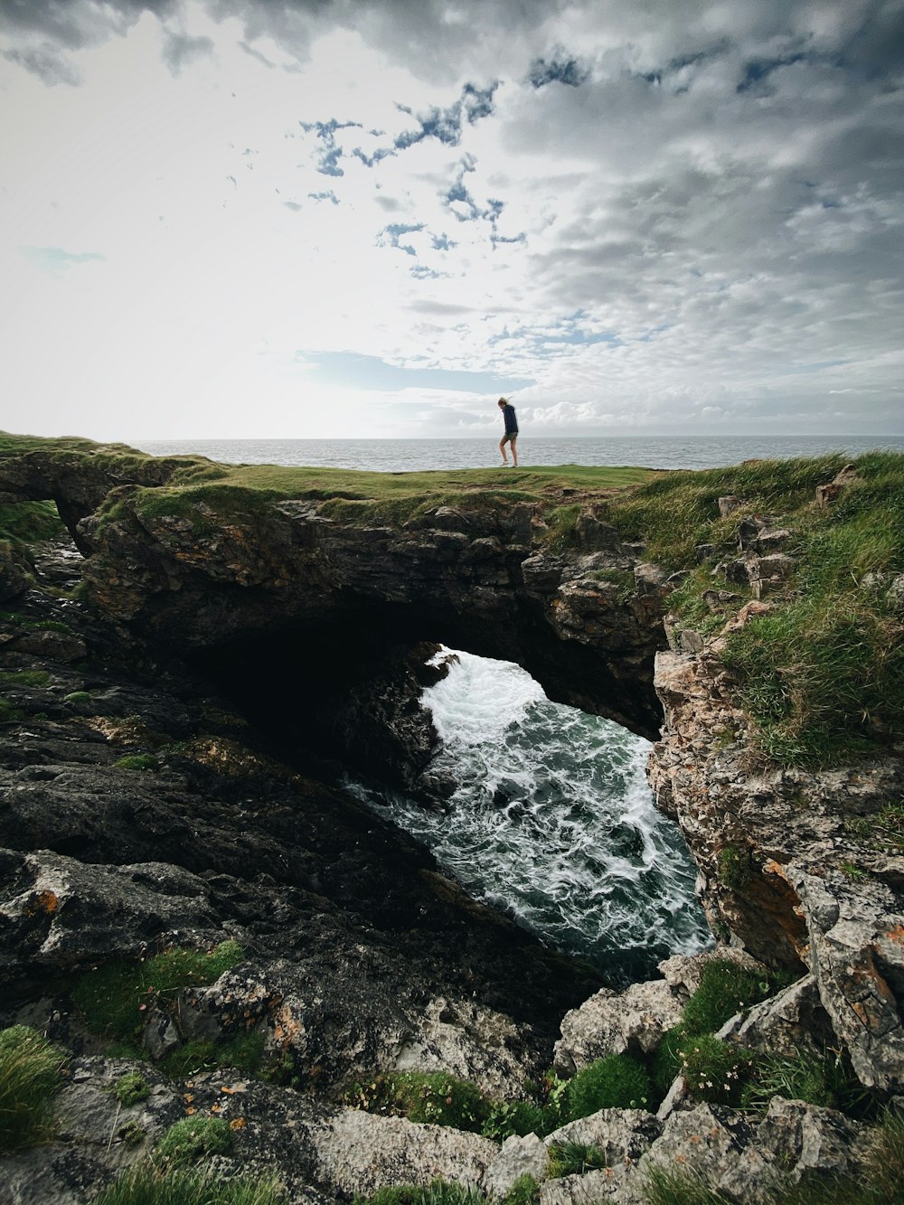 person standing on rock formation during daytime